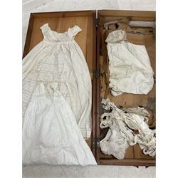 Late 19th century case containing brass and cream painted iron crib and bassinet by The Universal Folding Basket, together with an assortment of clothing, including letter from titled estate from Whitby