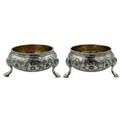 Pair of Victorian silver circular salts with gilded interiors, embossed with flowers and leaves on triple shaped supports London 1853 Maker William Robert Smily