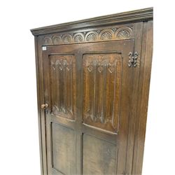 18th century design oak hall wardrobe, the moulded cornice over one hinged door with linen fold carved panels, opening to reveal interior fitted for hanging, raised on stile supports 