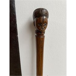 African Zulu assegai with short wooden haft L138cm and a Zulu stick carved with a head and dated 10/9/93 L87cm