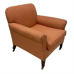 Howard & Sons - Edwardian mahogany framed armchair, traditional shape with rolled arms, upholstered in coral patterned fabric with sprung back and seat, with matching seat cushion, on square tapering supports with brass castors, the rear leg stamped '15881 5819 Howard & Sons Ltd Berners St'
Provenance: From the Estate of the late Dowager Lady St Oswald