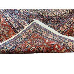 Persian Mood ivory ground carpet, the crimson and indigo floral medallion within a Herati decorated field, the multi-band border with repeating stylised plant motifs