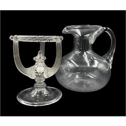 19th century clear glass water jug, of squat form with flared rim H17.5m, together with an early 20th cenutry Venetian glass stand, of circular form with twisted top section, three reeded supports and knopped stem on a domed circular foot (2)