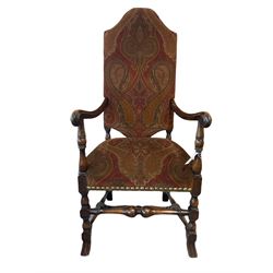 Charles II style high back upholstered carver armchair, upholstered in Paisley type patterned fabric decorated with scrolled Boteh motifs, open arms on turned supports joined by stretchers