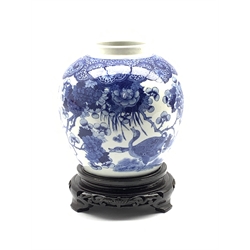 19th century Chinese blue and white jar decorated in underglaze blue with Butterflies and ducks in landscapes of flowering peonies and further flowers, below a ruyi and diaper border, with hardwood stand, H19cm