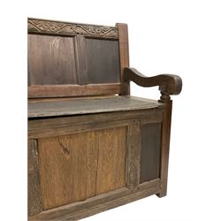 18th century and later settle, the cresting rail carved with scrolled foliage over four panelled back, lift up box seat, scrolled arms on turned supports panelled front and sides 
