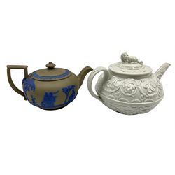 19th century Wedgwood drab ware teapot of squat circular form with green grey body and blue bands of figures and trees, impressed mark, H8cm and a Wedgwood white glazed teapot with raised flowers and spaniel lift, impressed mark H10cm (2)