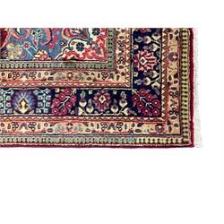 Persian fuschia ground rug, the central floral pole medallion surrounded by floral decoration, the blue spandrels with scrolling edges and flowerheads, the guarded border decorated with repeating stylised plant motifs