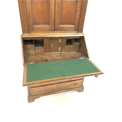 Georgian oak bureau bookcase, two arched fielded panelled doors enclosing four adjustable shelves, enclosed by fluted pilasters, over fall front revealing fitted interior, four long graduated drawers, raised on bracket supports, W97cm, H220cm, D53cm