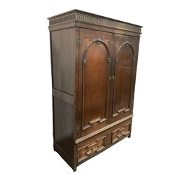 Late 18th century oak hanging cupboard, the projecting cornice over fluted frieze surmounting two panelled doors with geometric and rounded design enclosing hanging rail, leading into two drawers in geometric design, raised on stile supports W135cm, H195cm, D58cm