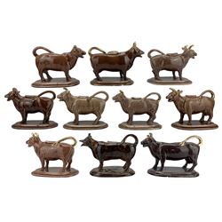 Ten 19th century brown glazed cow creamers, each set upon oblong bases, one decorated with a Rockingham type glas on relief moulded base (10)