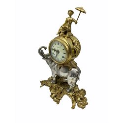 Decorative spring driven two train mantle clock striking the hours on two bells, enamel dial with roman numerals and five-minute Arabic’s, with minute markers and louis’ XV hands, dial inscribed “Imperial”, balance wheel eight-day movement housed in a decorative drum case resting on a silvered cast metal figure of an elephant with figure above. With key
