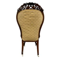 Victorian rosewood framed bedroom chair, pierced and scrolled floral carved cresting rail over seat and back upholstered in yellow floral fabric, scroll carved cabriole supports terminating in ceramic castors W49cm