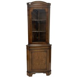 Mid 20th century walnut corner cabinet, fitted with one glazed door opening to reveal two shelves over one cupboard door with one shelf, raised on bracket supports 