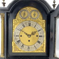 Edwardian - English ebonised 8-day bracket clock in a break arch case with flambe finials and reeded columns with Corinthian capitals to the front, silk backed brass side frets on an ogee plinth raised on bracket feet, brass dial with matted centre, slivered chapter ring and conforming dials for chime selection and chime/silent, three train chain driven fusee movement with an engraved backplate sounding the quarters on 8-bells and the hours on a coiled gong.  With pendulum and key.
