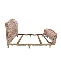 French style cream finish 4' 6'' double bedstead, the moulded frame with floral carved cresting rail, upholstered in cream ground fabric with crimson interlacing foliate pattern, with bed base and mattress