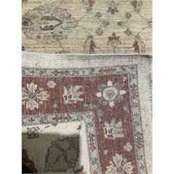 Beige ground rug with floral design and red border