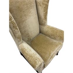 19th century wingback armchair upholstered in ivory fabric, raised on square tapering supports, terminating in brass castors 