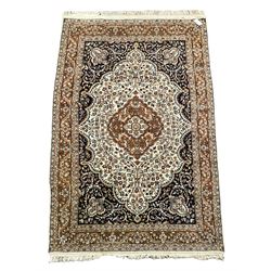 Ivory ground rug with one central medallion on a blue field, surrounded by multi-border and all over floral design