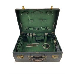 George V ladies green leather vanity case by J.W. Benson Ltd, the fitted green cloth interior comprising four silver mounted glass bottles, notepad, two inkwells, jewellery box, mother of pearl and silver implements, sewing case etc, tooled gilt makers label to front, L50cm, H19cm, D36cm