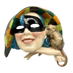 Essevi pottery wall mask modelled as a young woman, wearing green and yellow patchwork hat, and black eye mask, a marmoset by her ear, designed by Sandro Vacchetti, painted factory marks, 'Made in Italy No. 88 L.L' L34cm