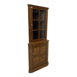 Albert Oldroyd - Oak corner display cabinet, fitted with bevelled glass door above panelled door, raised on plinth base