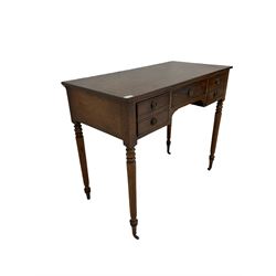 Regency mahogany writing table, the rectangular top over one long and two short drawers, raised on turned supports terminating in brass castors 