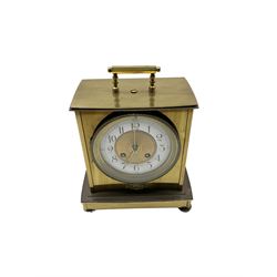 French - brass cased 19th century 8-day mantle clock, flat top with carrying handle, rectangular case on a shaped base, two part dial with an engine turned gilt centre, enamel chapter with Arabic numerals, minute dots and brass moon hands, decorative glazed bezel, rack striking movement striking the hours and half-hours on a bell. With pendulum.