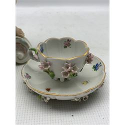 Meissen porcelain flower encrusted cup and saucer, hand painted with insects on six spur feet, together with a 20th century Sitzendorf twin handled urn and cover with Cherub finial and two further cherubs supporting the base H41cm