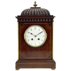 French – 19th- century 8-day Mahogany mantle clock with a carved pediment surmounted by a turned brass finial, flat top with a moulded cornice and carved frieze beneath, inlaid brass decoration to the corners, front and base, raised on bun feet, white enamel dial with Arabic numerals, minute markers and steel spade hands, enclosed within a convex glass and cast bezel, French square plated rack striking twin train movement, striking the hours and half hours on a coiled gong. With pendulum.