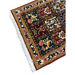 Persian Bakhtiari crimson ground rug, the field with three rows of panels depicting varying floral designs, banded ivory border with repeating flower heads and leafage