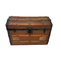 Early 20th century travelling trunk, hinged dome top with iron fittings, wood bound, on castors