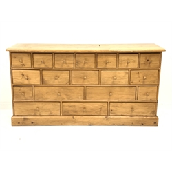 Waxed pine multi-drawer unit fitted with nineteen drawers, on plinth base, W179cm, H94cm, D48cm