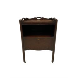 George III mahogany bedside cabinet, rectangular tray top with shaped raised sides and pierced handles, single sliding cupboard door with shaped apron, raised on quarter curved chamfered supports terminating in small brass castors, 