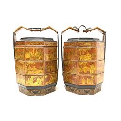 Pair of Chinese lacquered octagonal food or noodle carriers, with three tiers, carry handle and decorated with oriental scenes and motifs H67cm