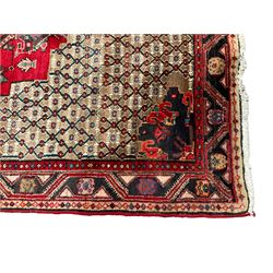 Persian Koliai camel ground rug, the central crimson medallion with an inner lozenge and stylised animal motifs, within a matrix style field of lattice and flower head patterns, triple banded border with geometric line work and stylised floral motifs