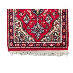 Small red ground rug, decorated with three lozenges (103cm x 62cm); and a small red ground rug with overall floral design (138cm x 69cm)