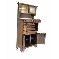 Edwardian mahogany dentists cabinet, the raised back with two bevel glazed doors each enclosing a shelf, over one bank of seven graduated drawers, another drawer, fall front cupboard and double cupboard to base, raised on castors H158cm