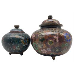 Two Japanese Meiji period Cloisonne jars and covers, of similar bulbous form on raised tripod bases, both decorated with butterflies and flower heads on a red and green ground, H10cm max (2)