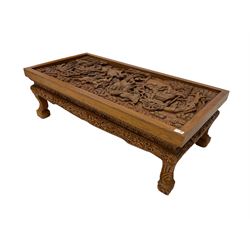 Carved hardwood coffee table, the rectangular inset carved with mythical battle scenes involved cavalry and dragon pulled chariots with arches outside a walled city, the frieze and apron profusely carved with repeating foliate decoration and flower heads, raised on cabriole supports