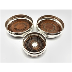Pair of silver coasters with turned wooden bases by W I Broadway & Co,  Birmingham 1981 & 1982 D14cm and another by W.E.V, London 1995 