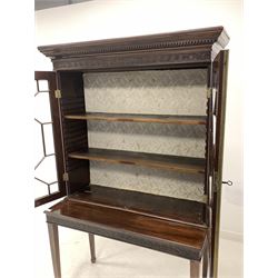 Early 20th century Chippendale style mahogany bookcase on stand, dentil cornice over carved frieze and two astragal glazed doors enclosing two shelves, the bottom section with matching carved frieze and raised on square tapered supports with peg feet W107cm, H182cm, D51cm