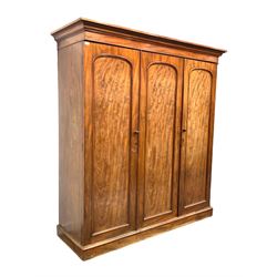 Victorian mahogany triple wardrobe, projecting cornice over plain frieze, three panelled doors enclosing interior fitted for hanging and with four drawers, raised on plinth base W183cm