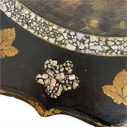 Victorian black lacquered papier-mâché occasional table, the shaped tilt-top decorated with painted landscape scene within a mother-of-pearl inlaid border, decorated with further mother-of-pearl and gilt foliage, on a turned stem, the platform base decorated with gilt work, on splayed and shaped metal feet