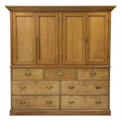 19th century ash housekeepers cupboard, the projecting cornice over four panelled cupboards, the interior fitted with two fixed shelves, the base fitted with three short and four long drawers, on a plinth base