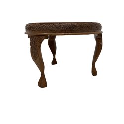 Early 20th century carved  Burmese hardwood occasional table, the top carved with flower heads and birds, on carved fulted supports terminating to clawed feet 