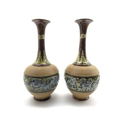Pair of Doulton Lambeth bottle shape vases decorated with a raised band of flowers on a green and brown ground H40cm one monogrammed LB possibly for Lucy Barlow
