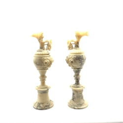 Pair of veined alabaster ewers, the handles modelled as trailing fruiting vines on turned socle bases, H53cm