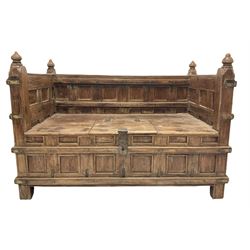 Large Indian hardwood bench, the panelled back and arm terminals over seat with hinged door for storage, raised on stile supports W145cm, H100cm, D77cm