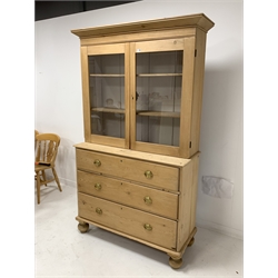 Victorian polished pine cabinet on chest, projecting cornice over two glazed doors enclosing interior fitted with two shelves, three long drawers under, raised on turned supports 